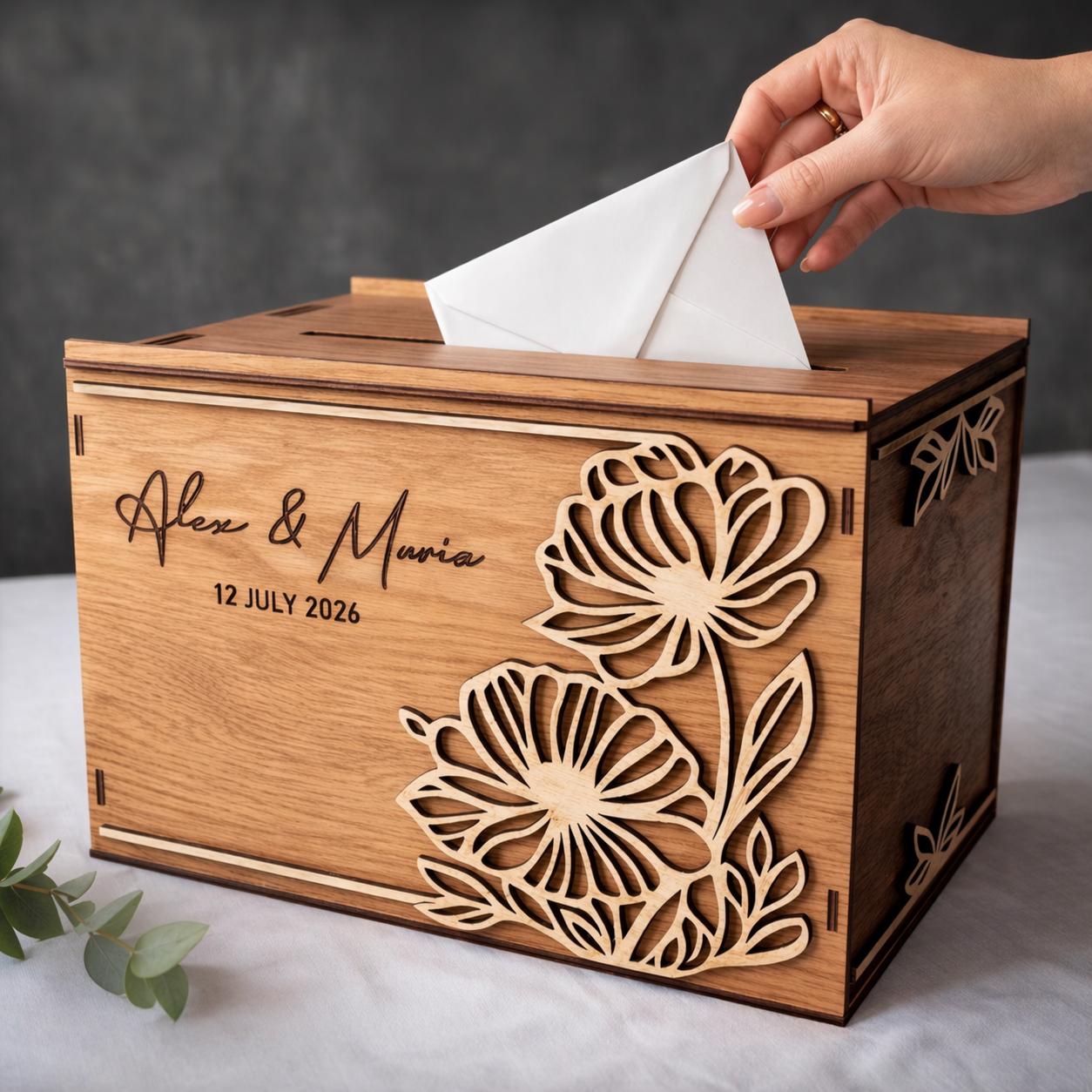 Personalized floral wooden wedding card box as a hand places an envelope through the top slot.